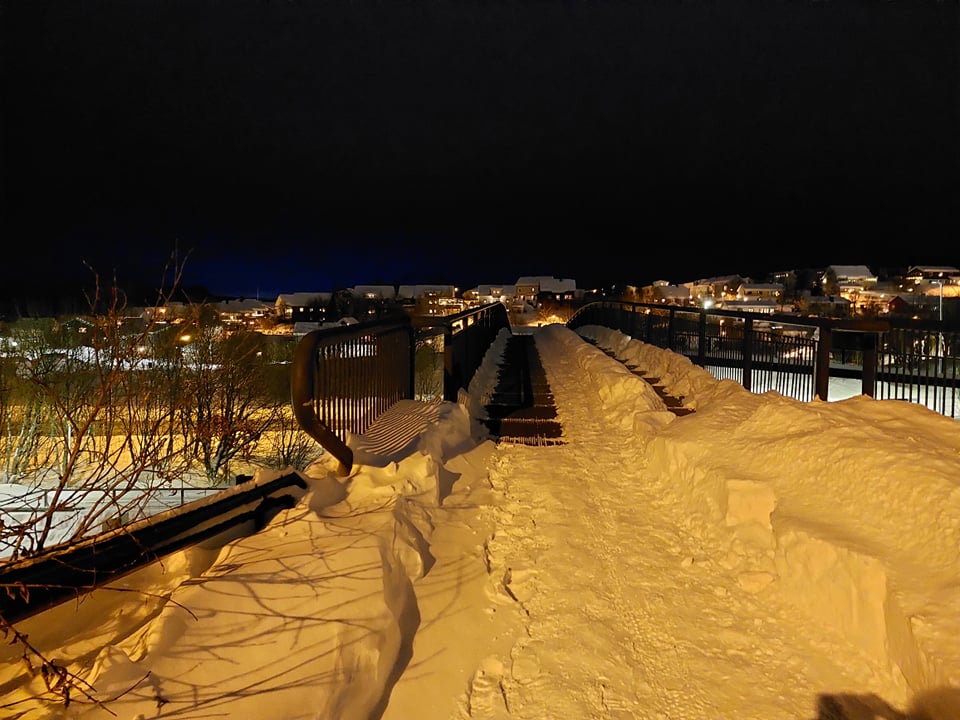 Gangbrua over riksvegen på Mørkved en vinterkveld. Det har snødd mykje, men det er brøyta.